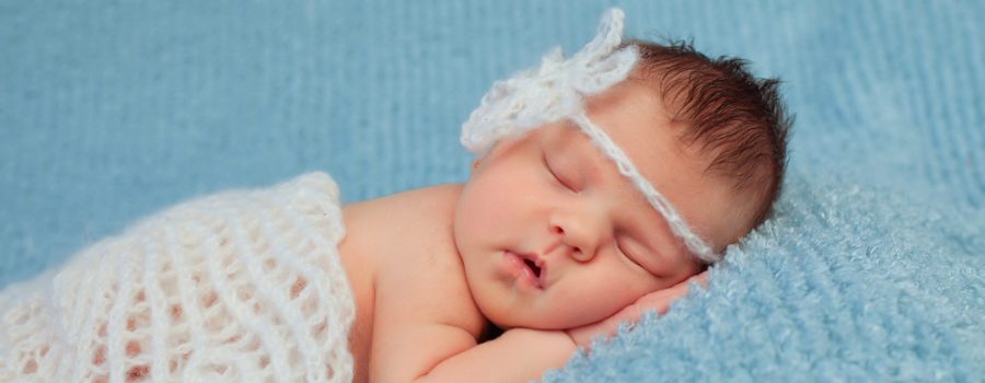 Close-up portrait of a beautiful sleeping baby on blue.0-7 deys baby. New born baby. Soft focus.